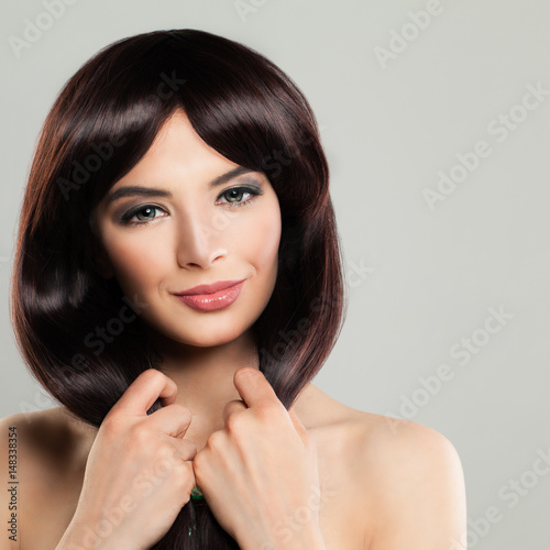 Beautiful Model Girl with Long Healthy Hairstyle. Cute Woman Touching her Hands her Brown Color Hair
