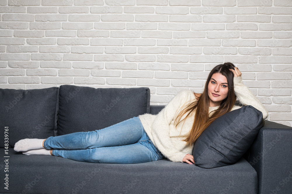 smiling young woman lying on sofa at home smiling young woman lying on sofa at home