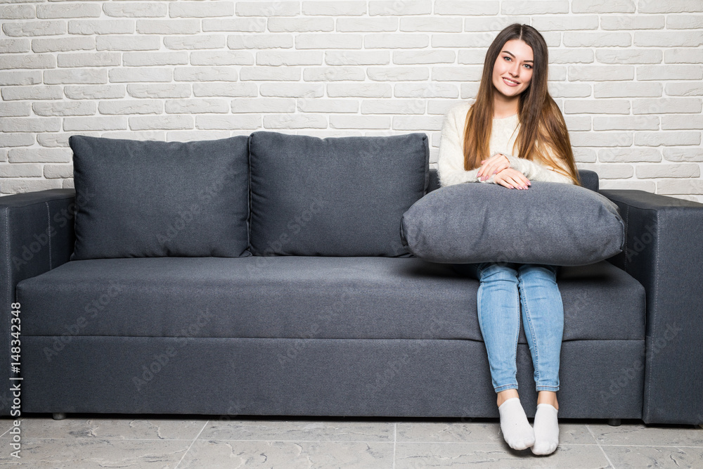 Obraz premium Happy young woman lying on couch and relaxing at home