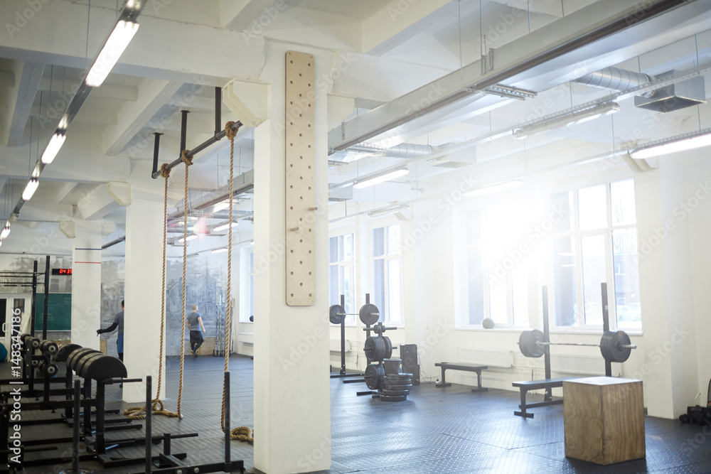 © pressmaster - Background image of various equipment in gym: exercise stands with climbing rope and barbell benches in empty sunlit hall © pressmaster - Background image of various equipment in gym: exercise stands with climbing rope and barbell benches in empty sunlit hall