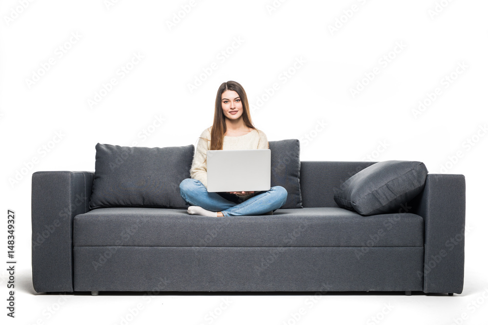 Young woman lying on couch and using laptop at home Young woman lying on couch and using laptop at home