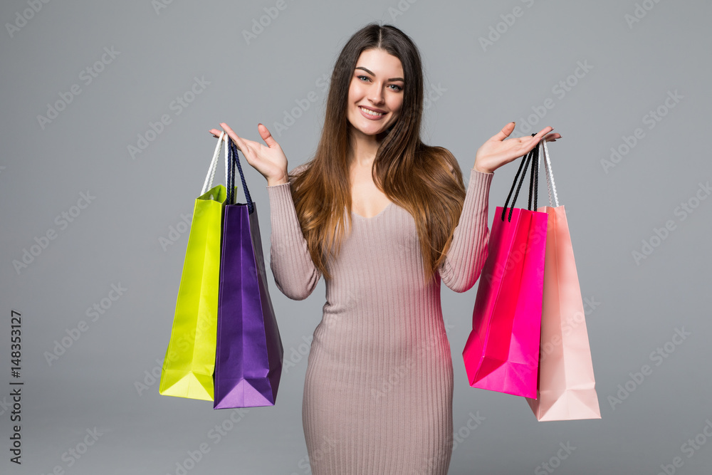 Woman with many shopping bags on gray background Woman with many shopping bags on gray background