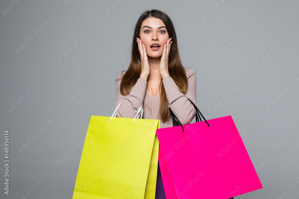 Young happy woman shopping bags over grey background Young happy woman shopping bags over grey background