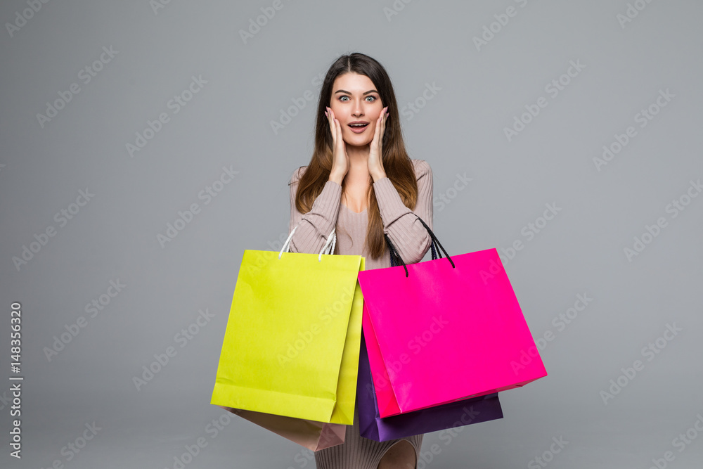 Young happy woman shopping bags over grey background