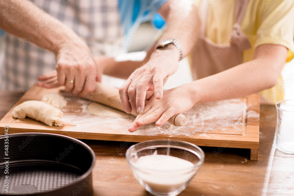 grandfather and granddaughter making dough