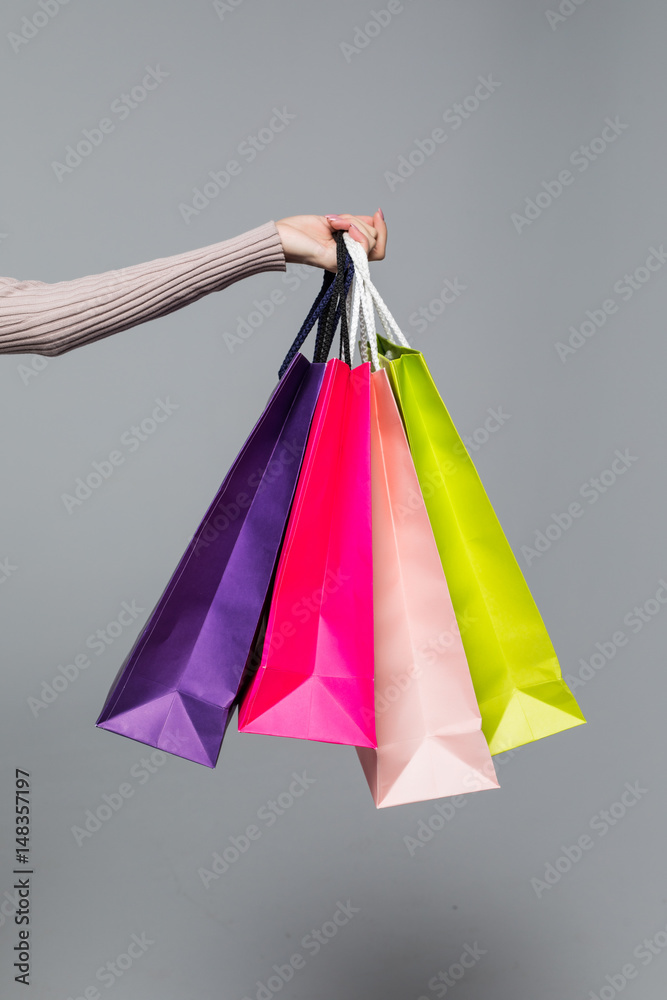 Young summer shopping woman with shopping bags isolated on grey background