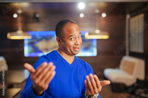 Handsome African businessman in blue suit in cafe. Not isolated