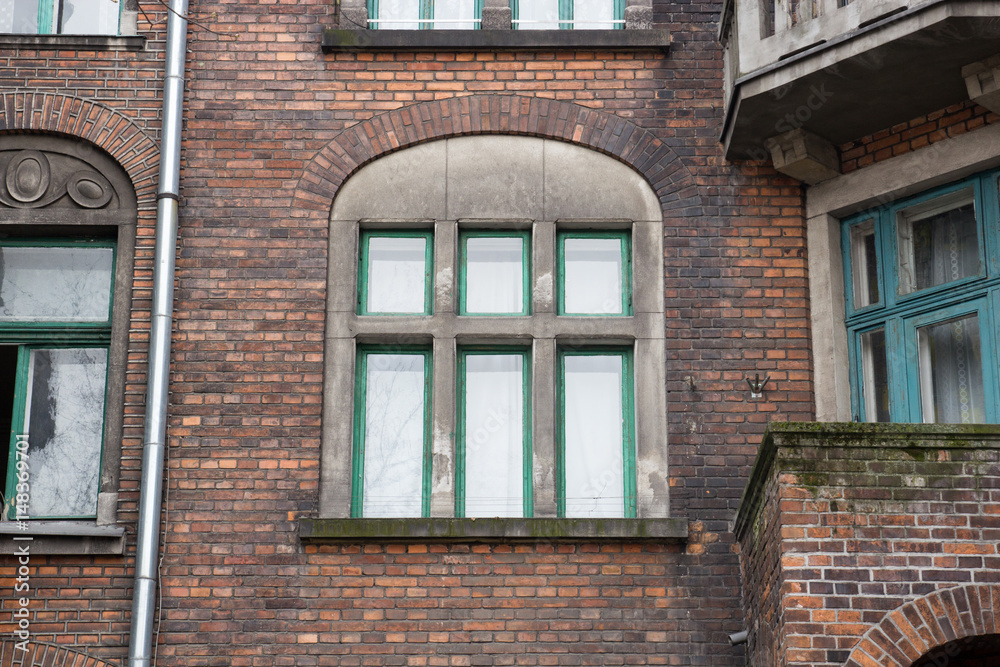 Facade of old brick building with Windows and drain pipe