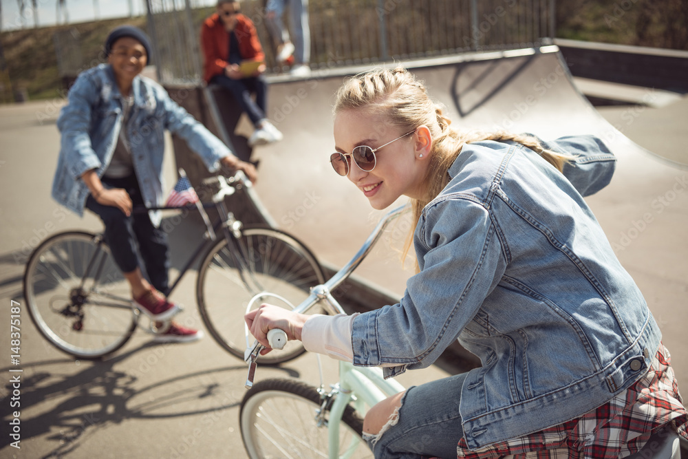 teenagers having fun and riding bicycles in skateboard park, bike riding city concept