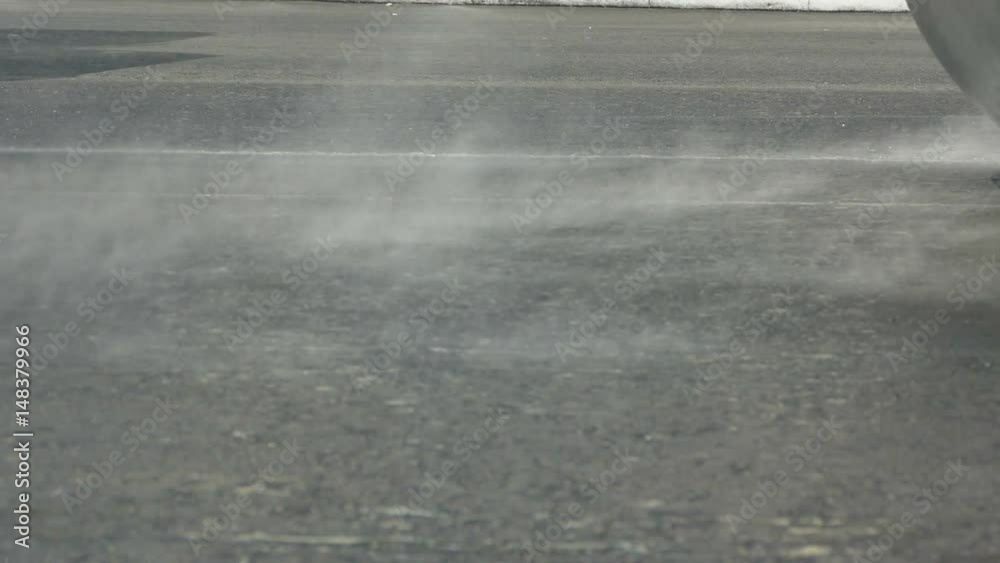 The asphalt compactor just laid the asphalt and now the steam comes from the road. Ukraine, 2017 The asphalt compactor just laid the asphalt and now the steam comes from the road. Ukraine, 2017