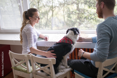 Beautiful couple relaxing at home and loving their dog