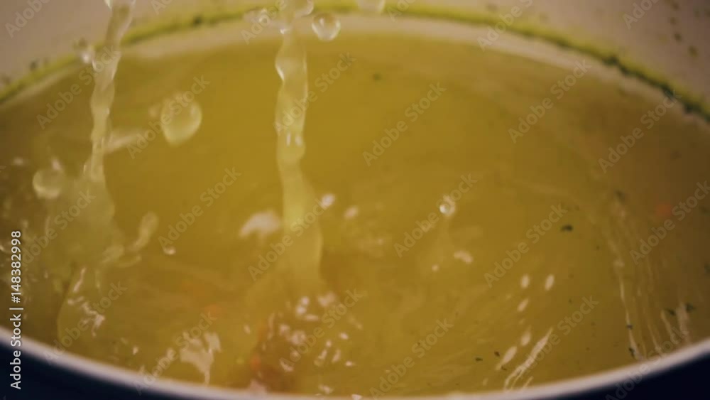 To pick up a broth in the ladle. A small ladle in a saucepan with vegetable broth. Slow motion To pick up a broth in the ladle. A small ladle in a saucepan with vegetable broth. Slow motion