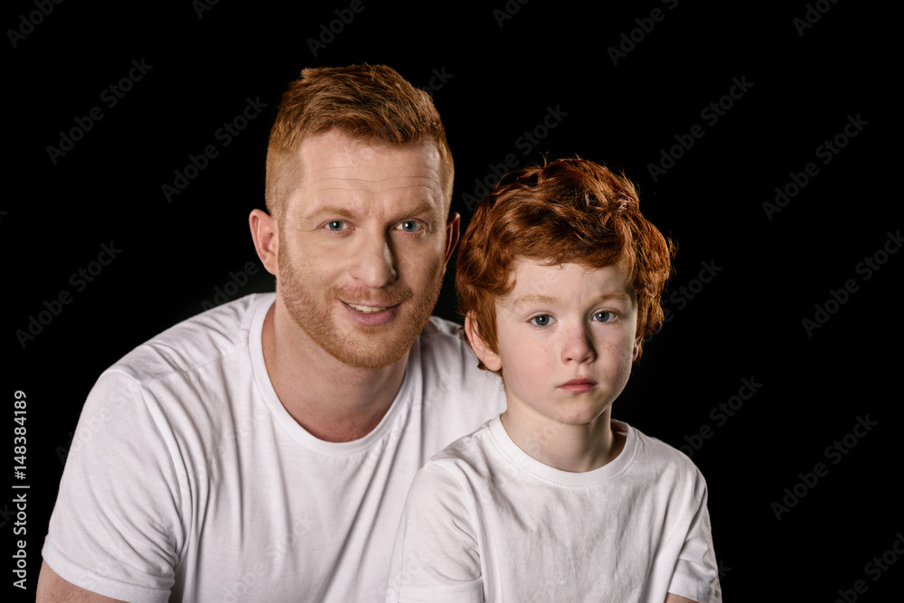 Happy father with son wearing white t-shirts isolated on black Happy father with son wearing white t-shirts isolated on black
