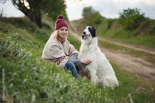 Cute blonde woman with her dog playing outdoor