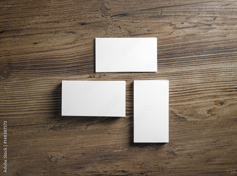 Piles of blank business cards on wood table background. Mock up for ID. Blank template for branding identity. Top view. Piles of blank business cards on wood table background. Mock up for ID. Blank template for branding identity. Top view.