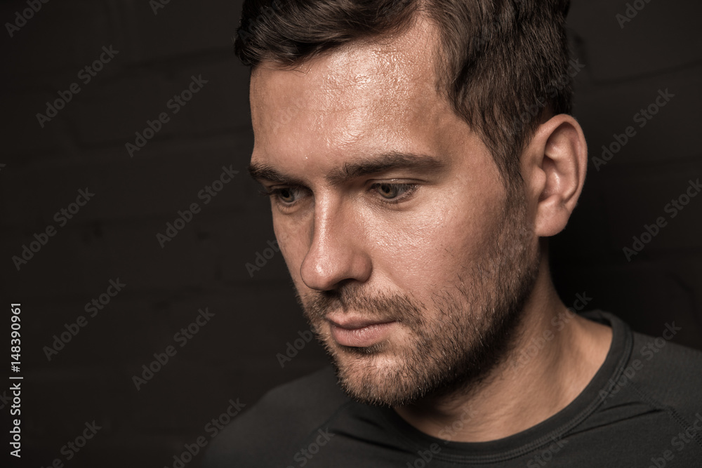 Thoughtful young man, close-up portrait on black Thoughtful young man, close-up portrait on black