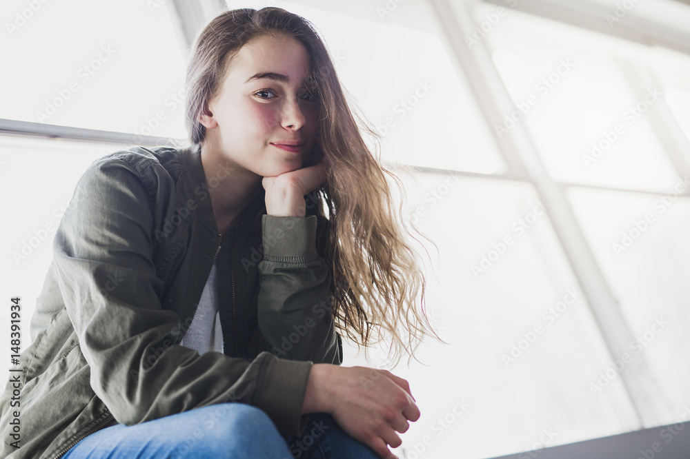 Teenager girl sitting on window Teenager girl sitting on window