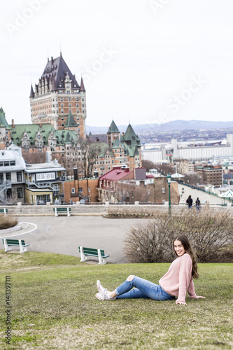Quebec City scape with Chateau Frontenac and young teen enjoying the view.