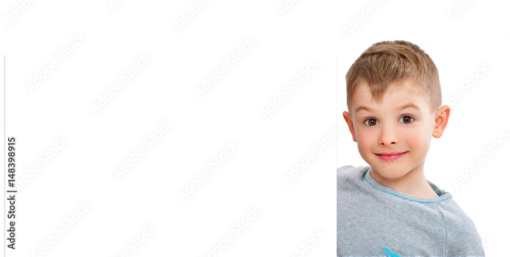 Portrait of a cute boy, peeking from behind a banner, isolated on white background Portrait of a cute boy, peeking from behind a banner, isolated on white background