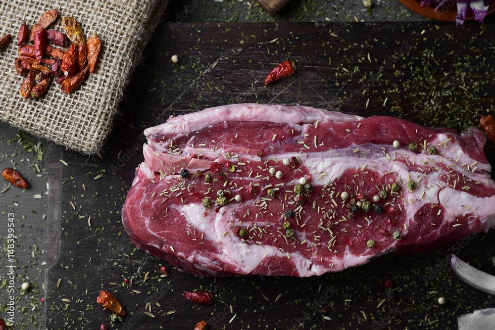 raw strip steak seasoned with different spices