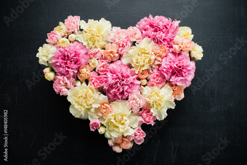 Heart from fresh flowers on a dark wooden background