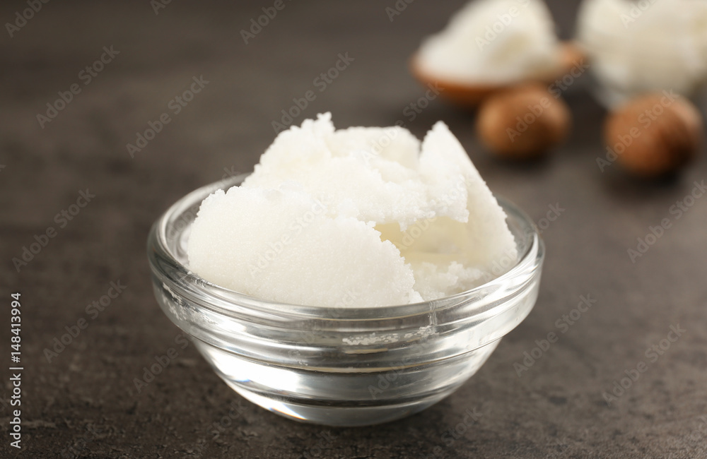 Shea butter in glass bowl on table, close up