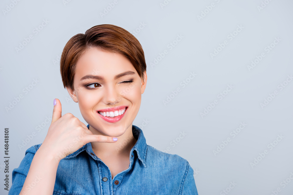 Portrait of beautiful smiling woman gesturing and asking to call her on light blue background Portrait of beautiful smiling woman gesturing and asking to call her on light blue background