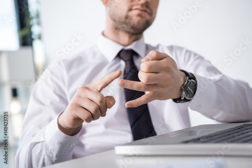 partial view of businessman counting on fingers at workplace, business concept photo