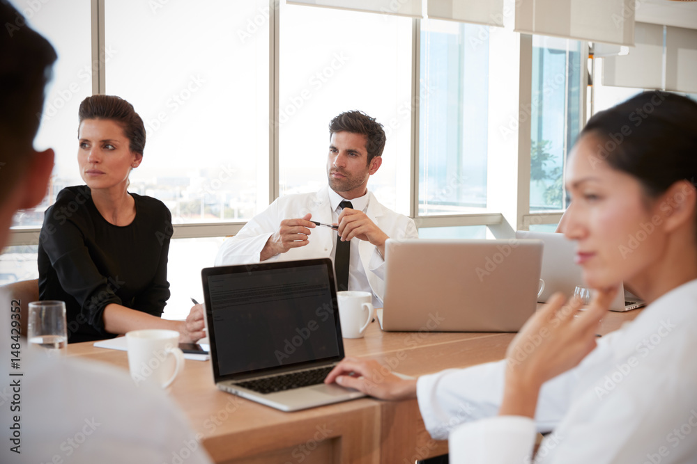 Group Of Medical Staff Meeting Around Table In Hospital Group Of Medical Staff Meeting Around Table In Hospital