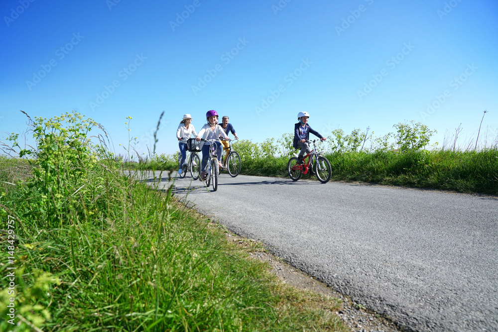 Fototapeta premium Happy family riding bikes on week-end in countryside