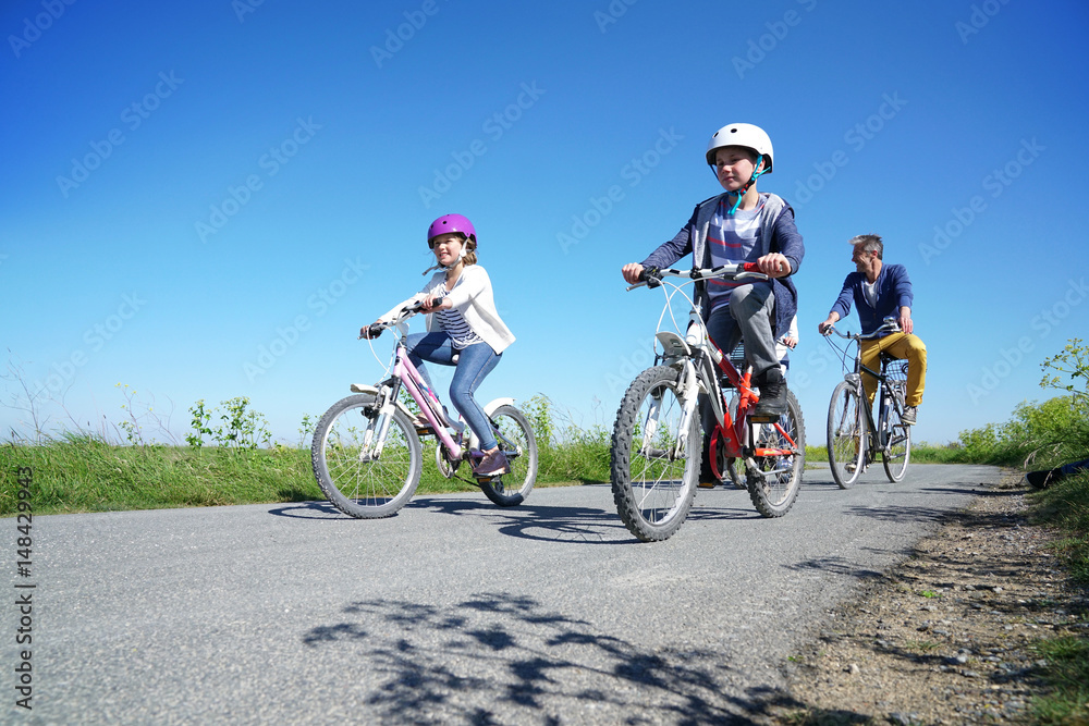 Happy family riding bikes on week-end in countryside Happy family riding bikes on week-end in countryside