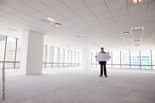 Male Architect In Modern Empty Office Looking At Plans