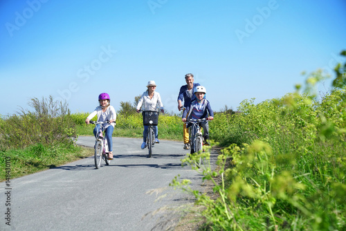 Fototapeta Naklejka Na Ścianę i Meble -  Happy family riding bikes on week-end in countryside