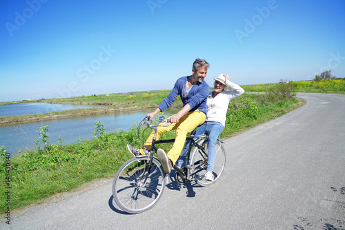 Cheerful couple riding bike on a sunny day