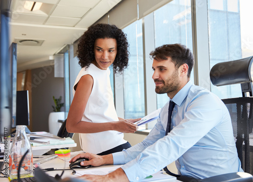 Businesspeople Working At Office Desk On Computer Together