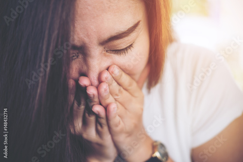 Valokuvatapetti Close up image of an Asian woman while sneezing