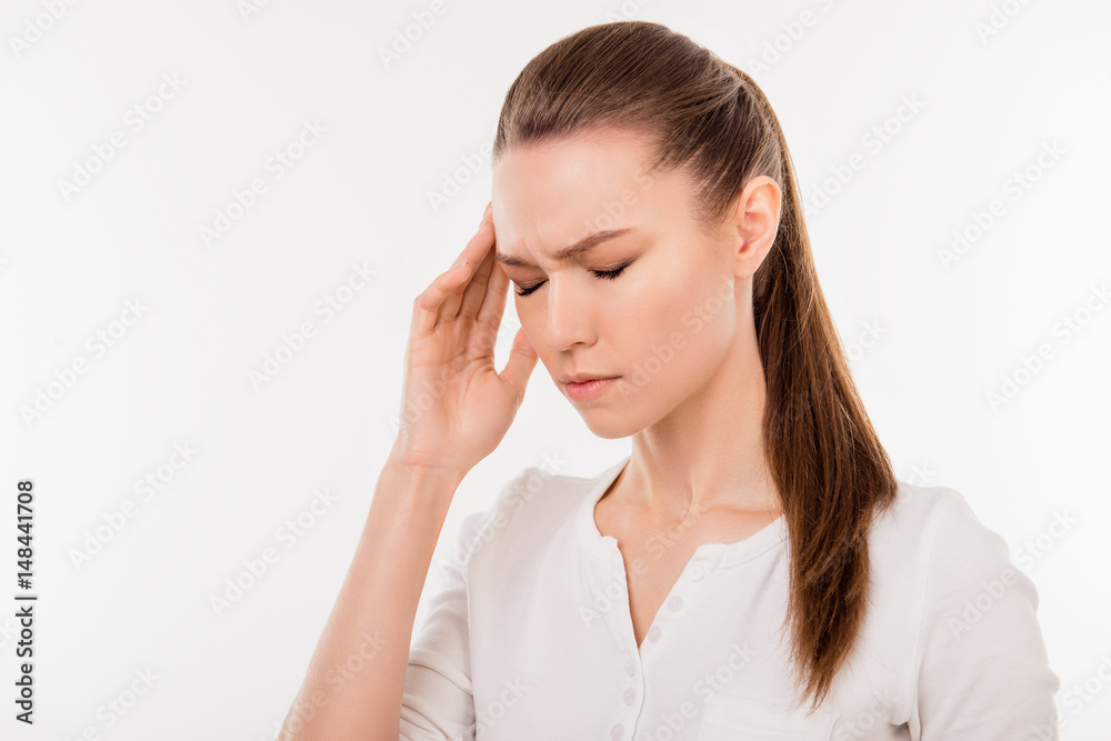 Young depressed girl with closed eyes touching her temple because of having terrible headache Young depressed girl with closed eyes touching her temple because of having terrible headache
