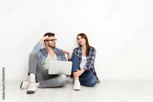 Couple web-surfing with laptop in empty room