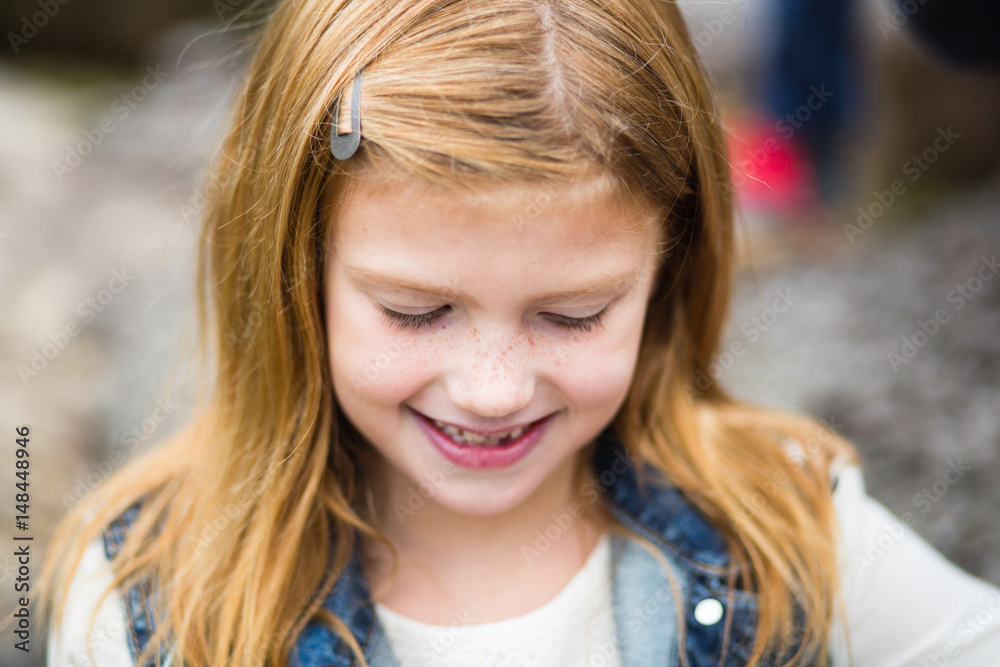 Girl with red hair smiling and looking down Girl with red hair smiling and looking down