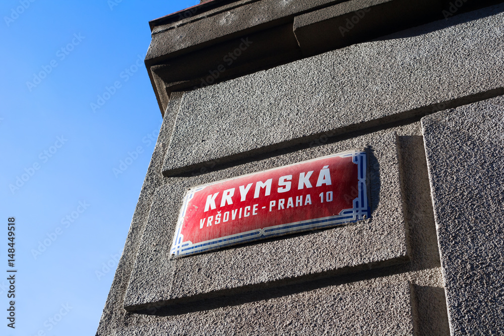 Fototapeta premium Krymska street, Vrsovice district, Prague city, Czech Republic / Czechia - street name sign on the wall. Place is popular and famous among tourists and locals