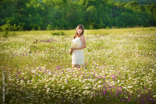 Mom and daughter on a picnic in the chamomile field. Two beautiful blondes in chamomile field on a background of horse. Mother and daughter embracing in the chamomile field