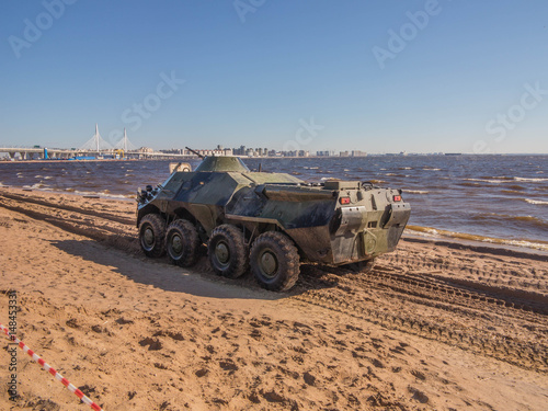 Armored personnel carrier on sand against the blue sky