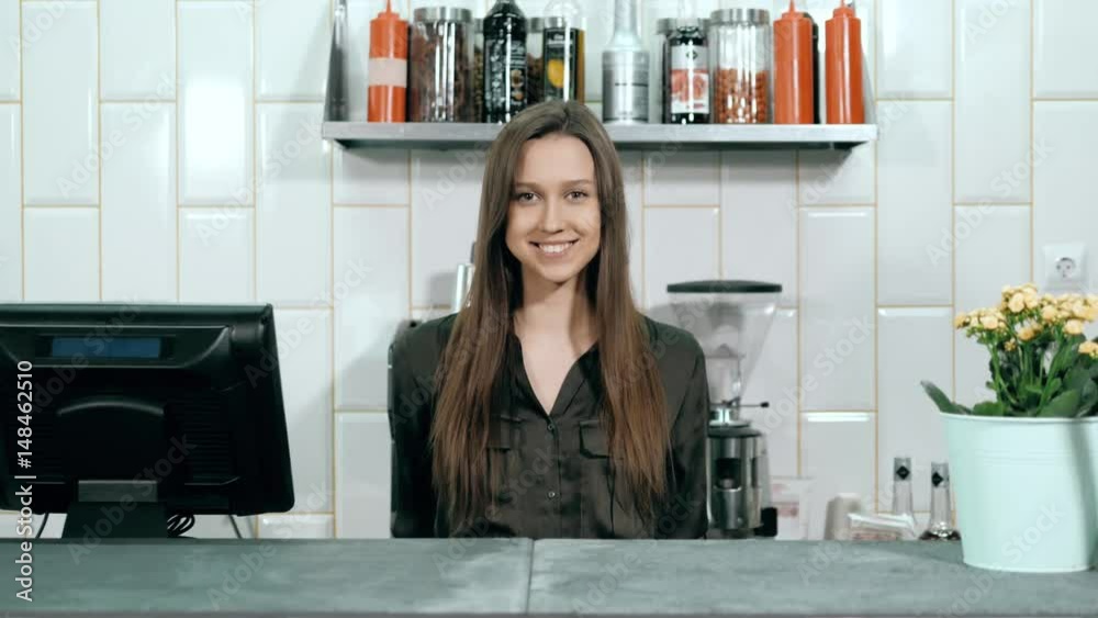 cheerful waitress standing behind the bar at cafe, beautiful woman in coffee shop near cashbox keeper cheerful waitress standing behind the bar at cafe, beautiful woman in coffee shop near cashbox keeper