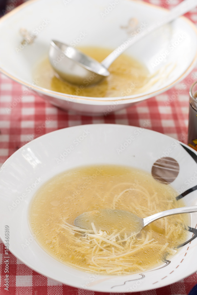 Domestic chicken soup served in the plate on the table Domestic chicken soup served in the plate on the table