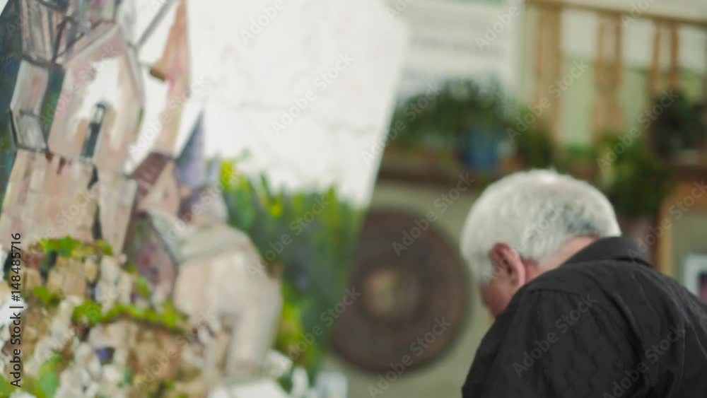 An elderly artist writes a picture in his studio 4k An elderly artist writes a picture in his studio 4k