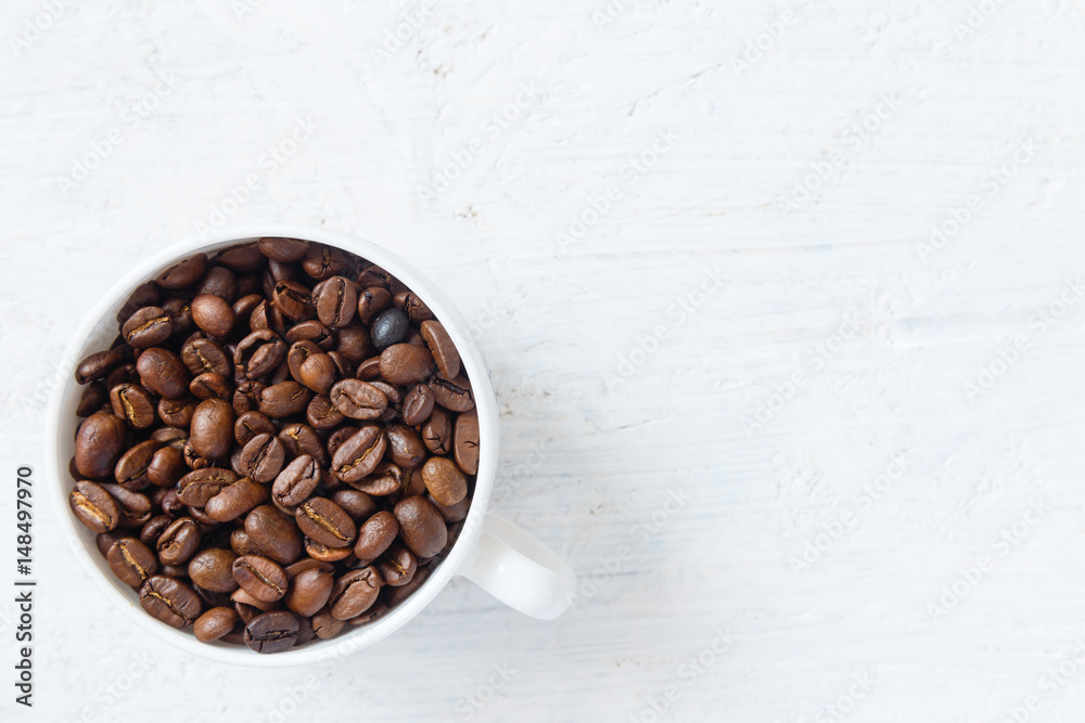 Coffee cup full of coffee beans on white background Coffee cup full of coffee beans on white background