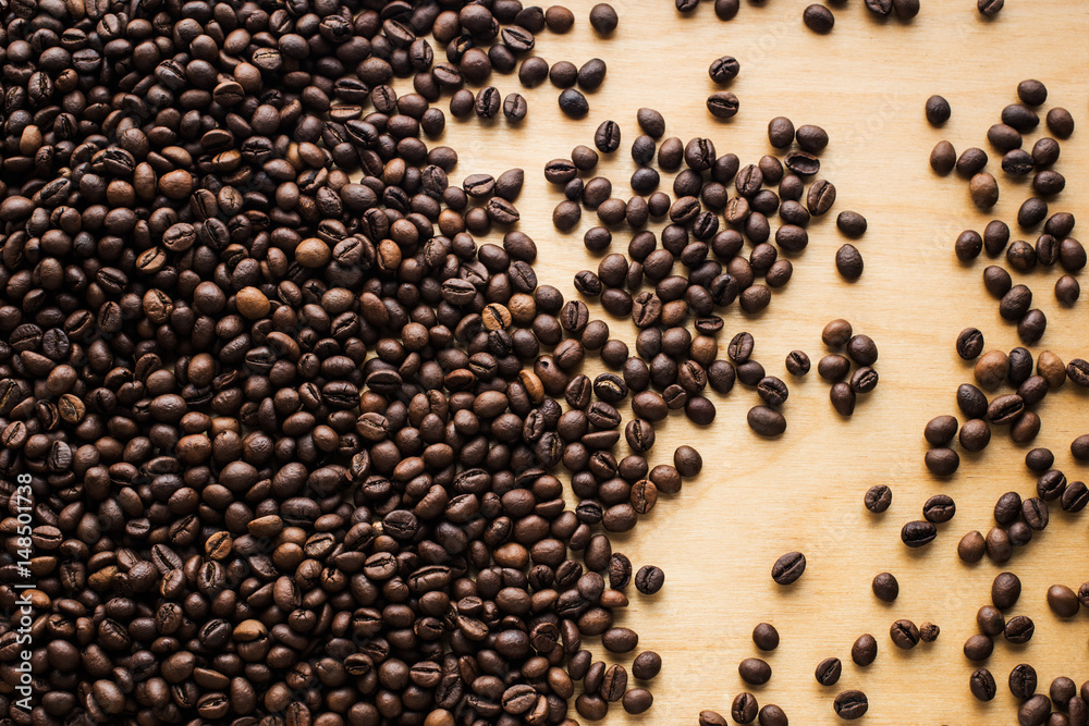 Background with coffee beans top on an old grunge wooden table Background with coffee beans top on an old grunge wooden table