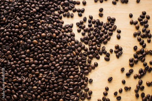 Background with coffee beans top on an old grunge wooden table © savelov