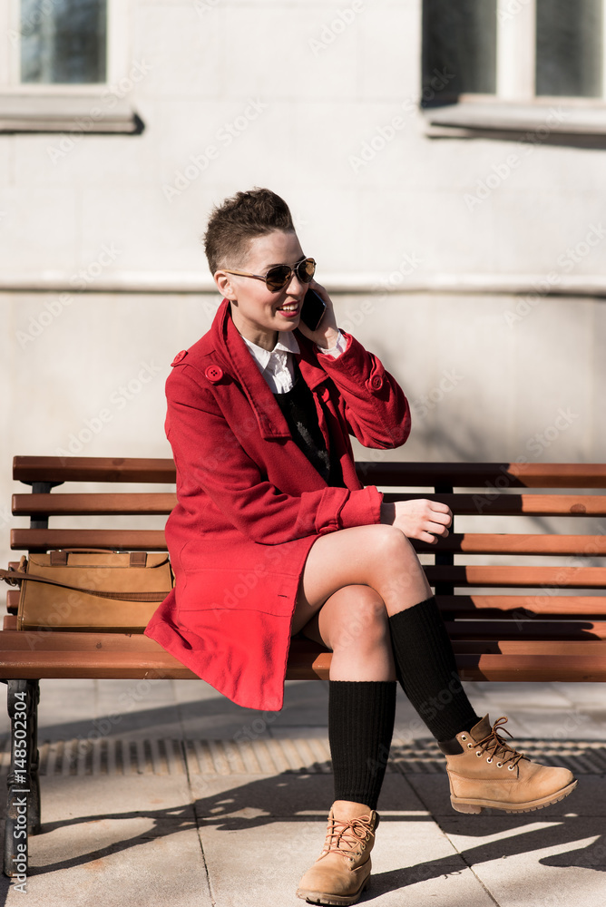 Fototapeta premium The model sits with a mobile on the bench