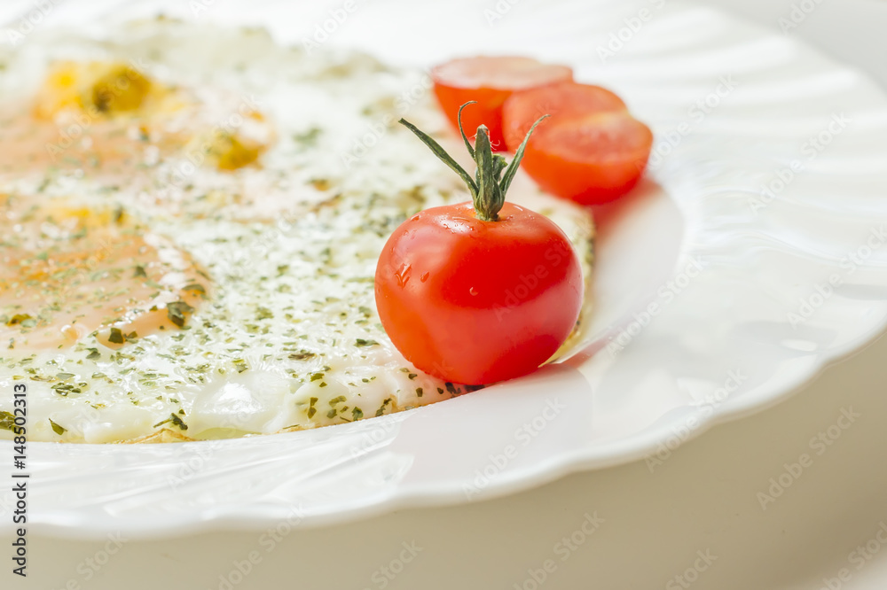 fried eggs on a plate with tomatoes and chopped parsley fried eggs on a plate with tomatoes and chopped parsley